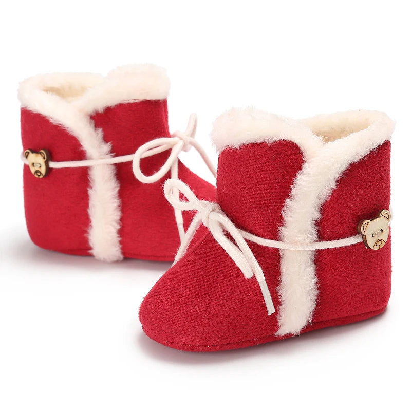 Red baby boots with white fur trim and bear buttons on a white background