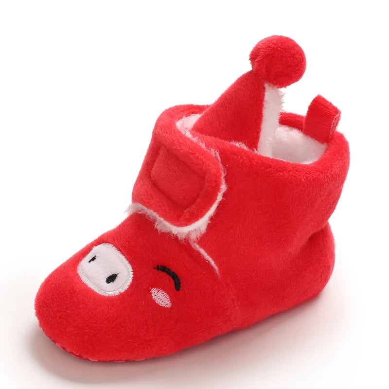 Red baby bootie with a smiley face design on a white background