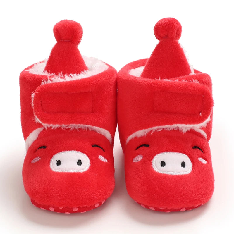 Red baby booties with cartoon face design on a white background