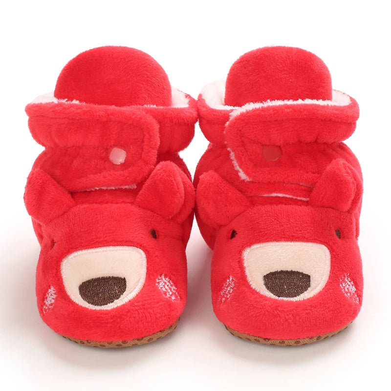Red baby booties with bear face design on a white background