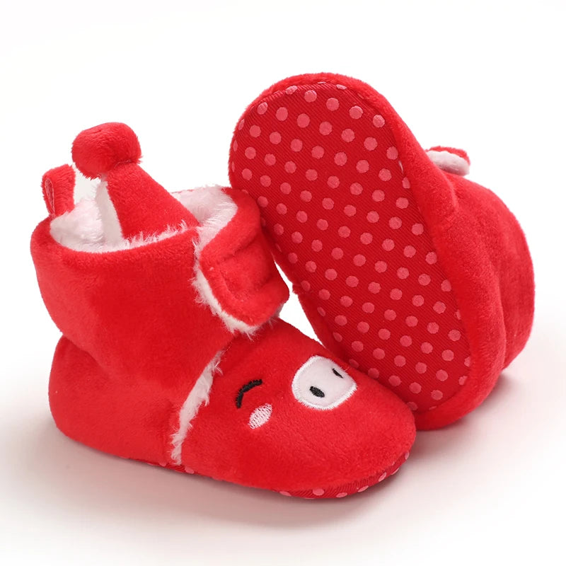 Red baby booties with white polka dot soles on a white background