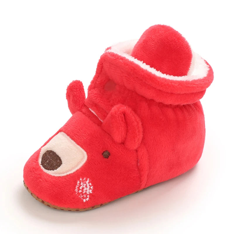 Red baby bootie with a face design on a white background