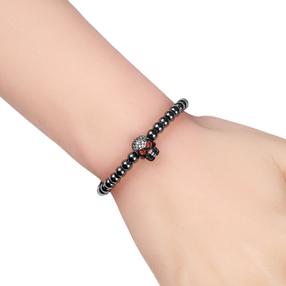 Black beaded bracelet with a skull charm on a wrist 