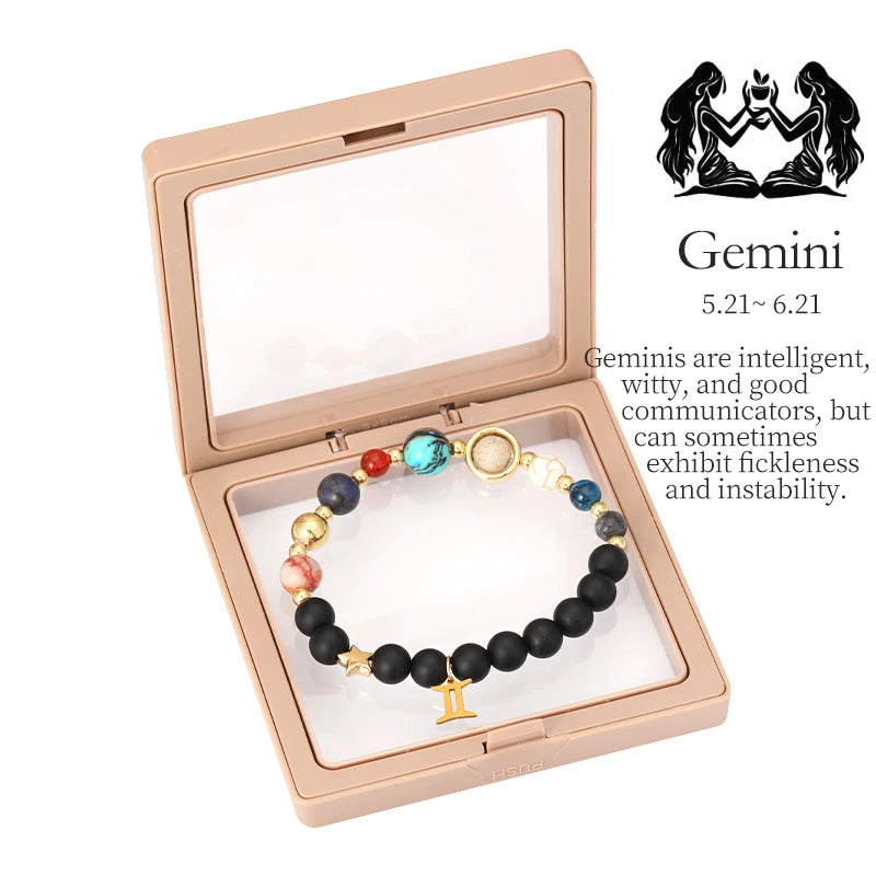 Bracelet with black beads and colorful accents in a rose gold box, featuring Gemini zodiac information.