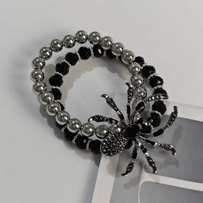 Bracelet with black and silver beads and spider charm on a white background