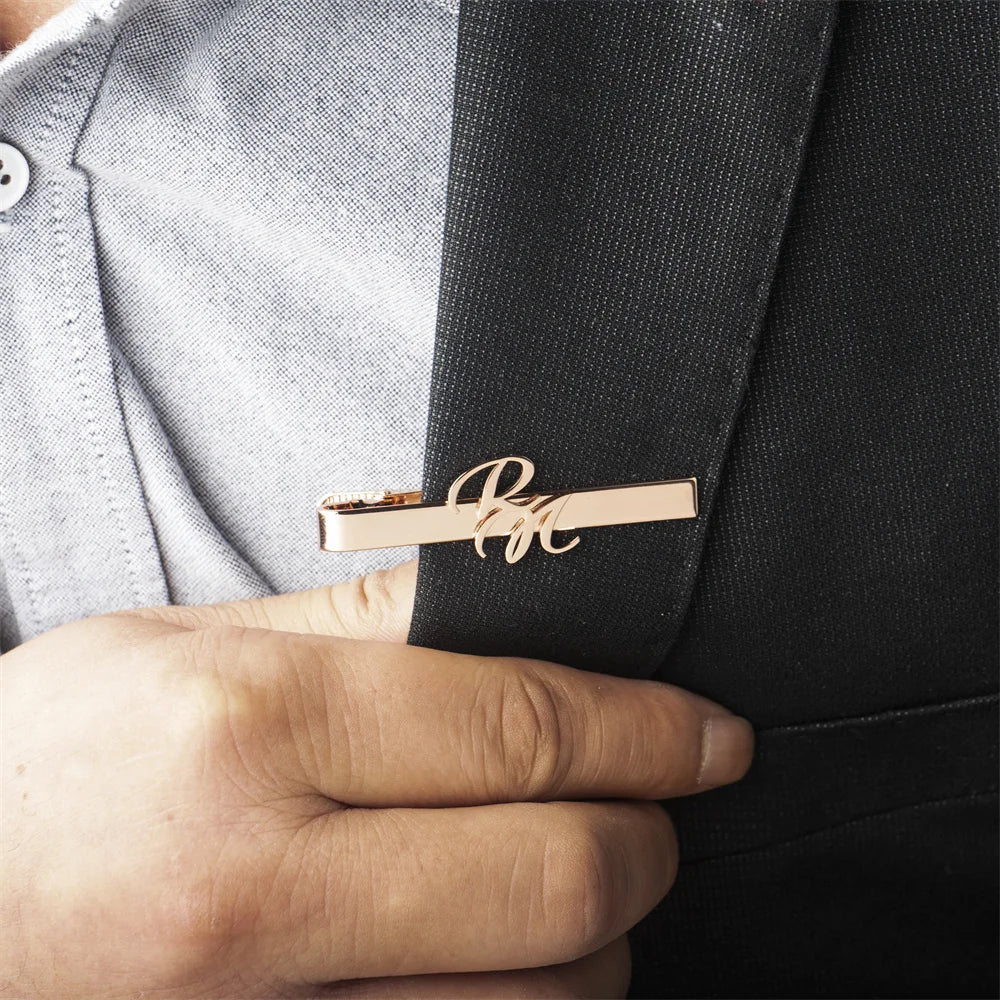 Customized rose gold tie clip being worn on a black suit