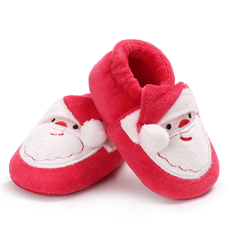Red baby slippers with Santa Claus face design on a white background