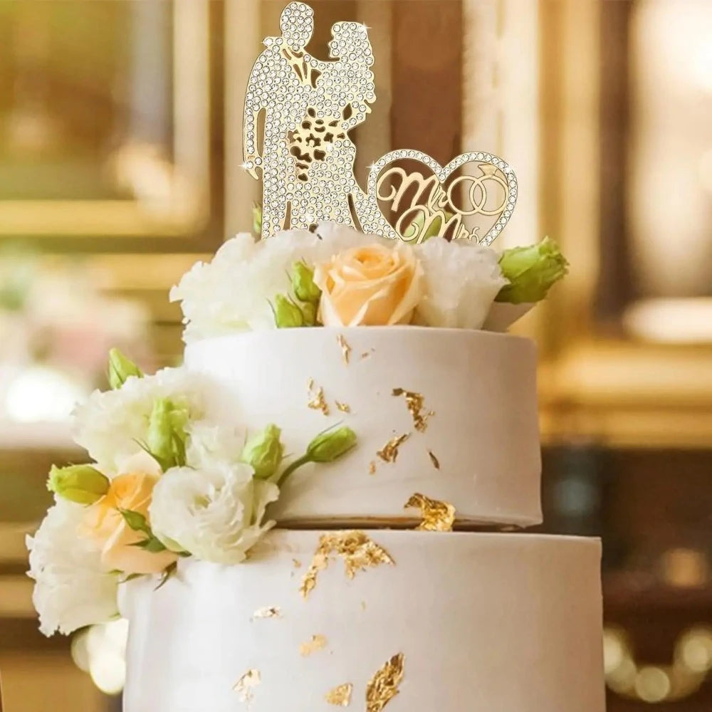 Decorative cake with floral arrangements and a 'Mr & Mrs' topper against a blurred background