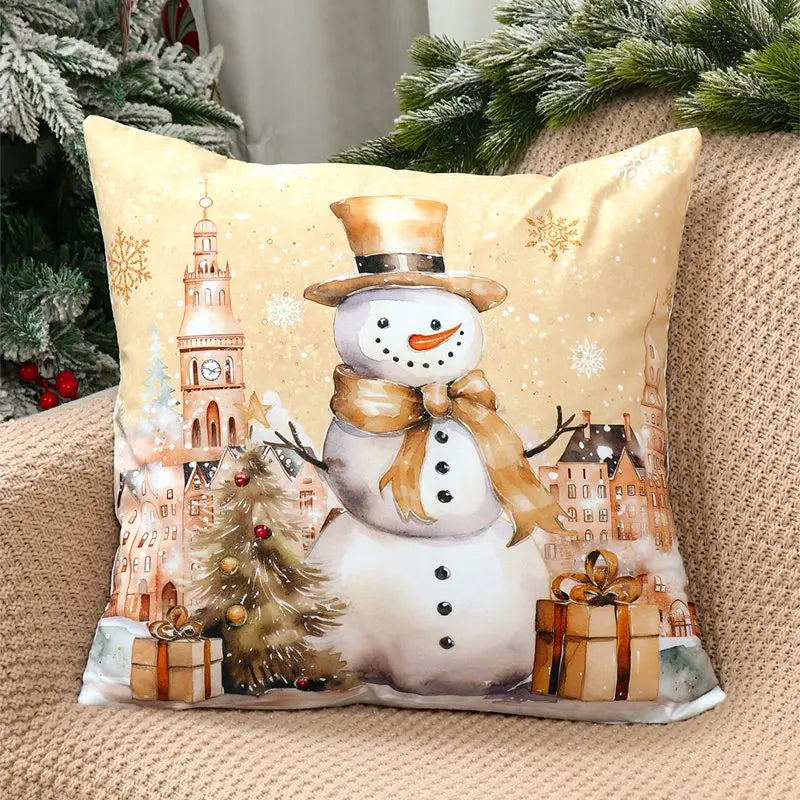 Decorative pillow with a snowman design featuring a Christmas village scene on a beige couch.