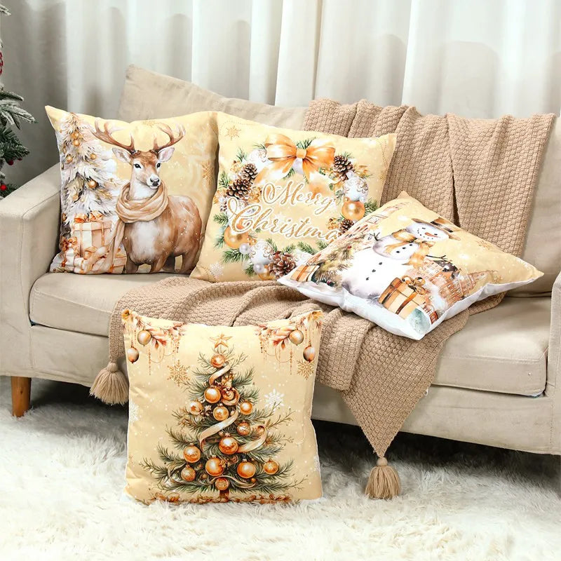 Decorative golden pillows with Christmas-themed designs on a beige sofa.