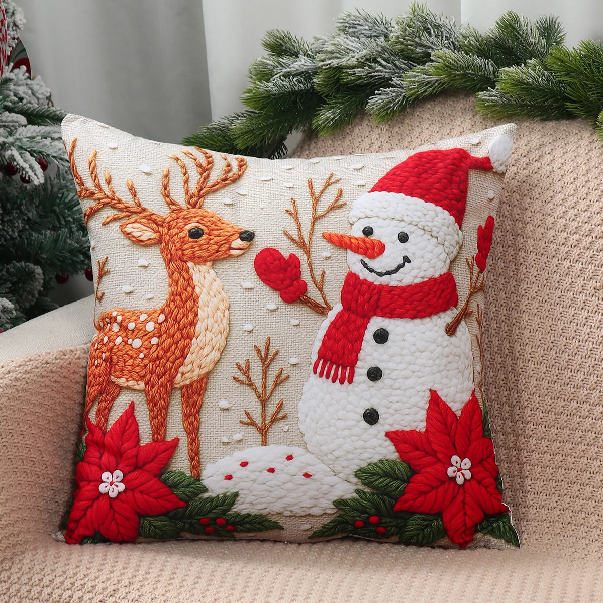 Decorative pillow with reindeer, snowman, and poinsettias on a couch.