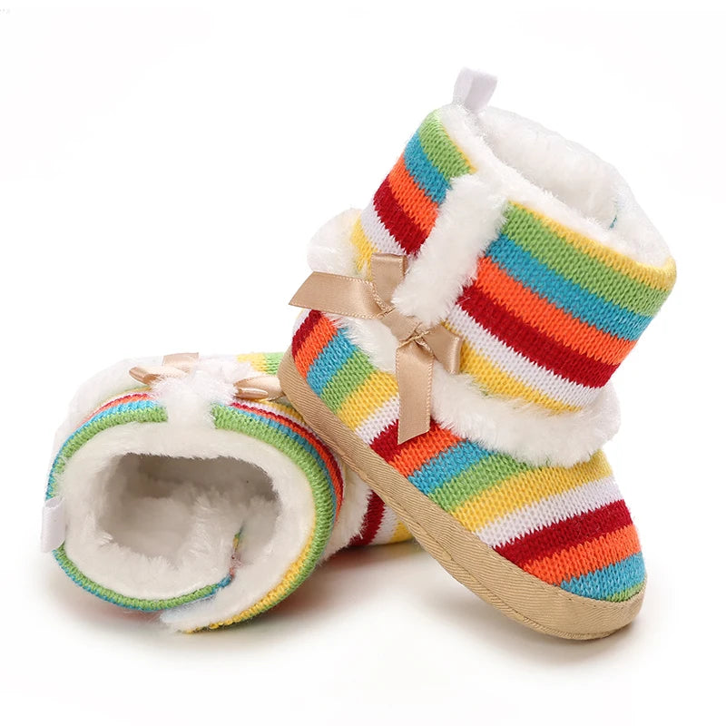 Colorful striped baby booties with white fur lining on a white background