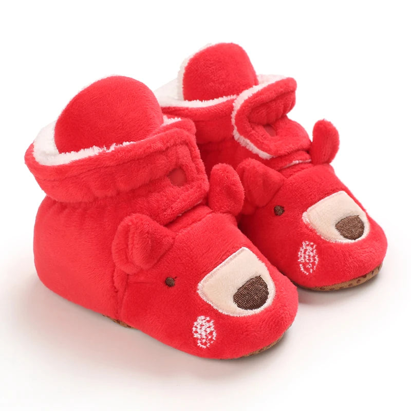 Red baby booties with a reindeer design on a white background