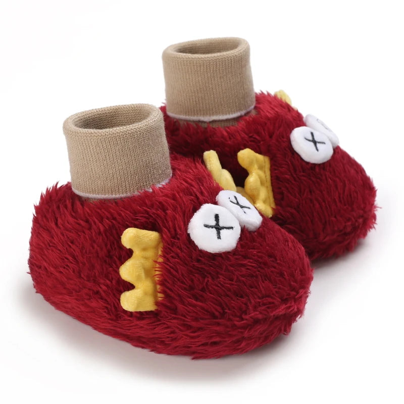 Red fuzzy baby shoes with beige tops on a white background