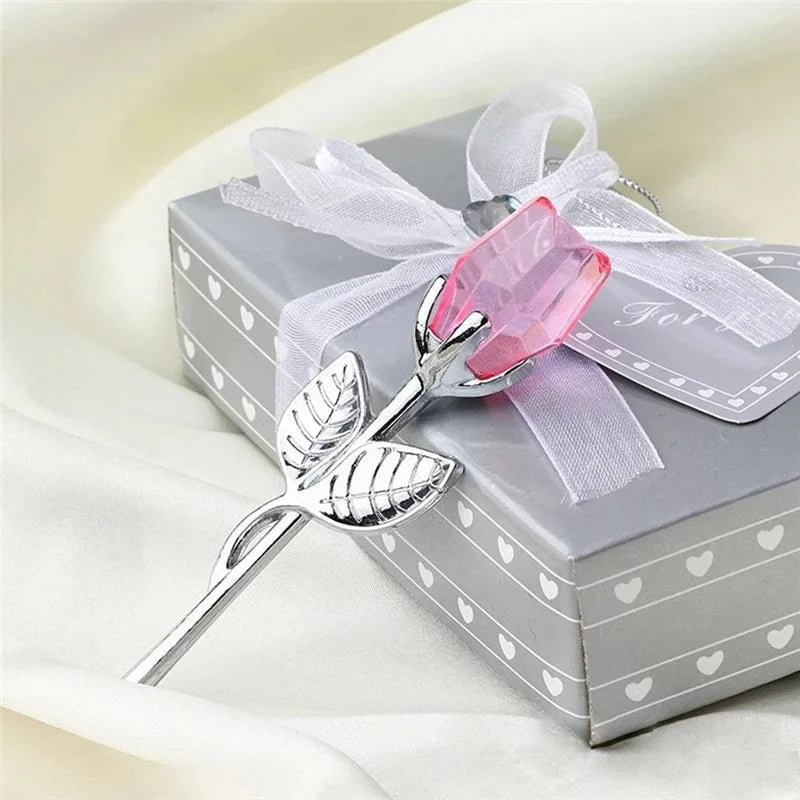 Decorative pink rose and silver accents on a gift box with a white ribbon.