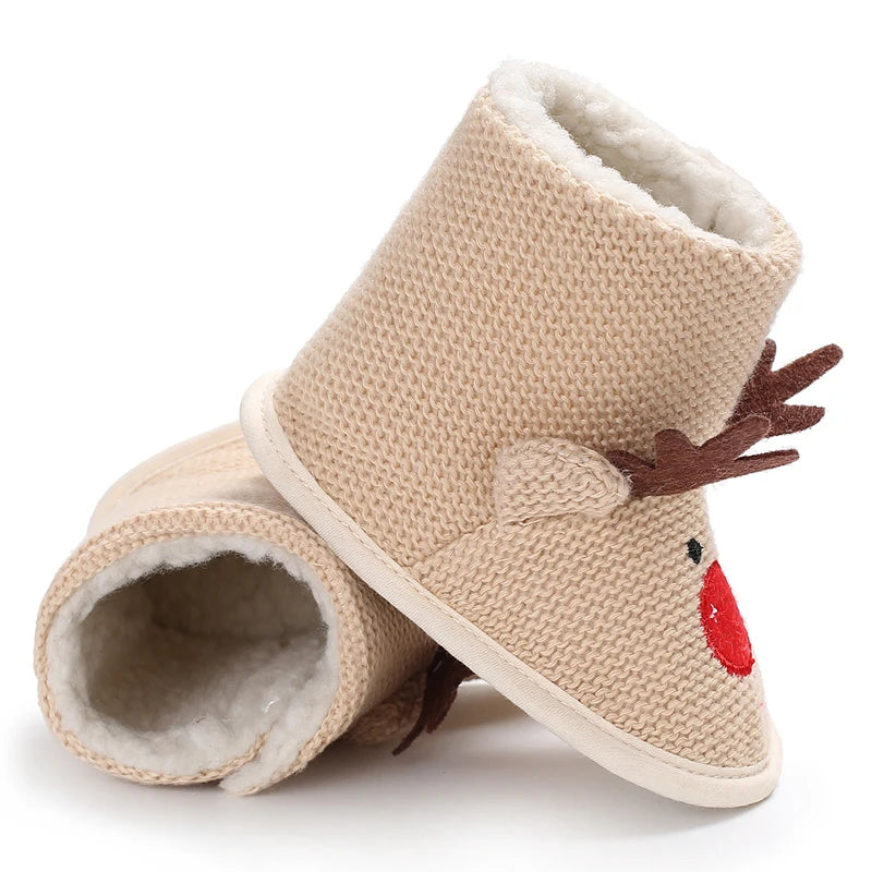 Beige knit slippers with reindeer design on a white background