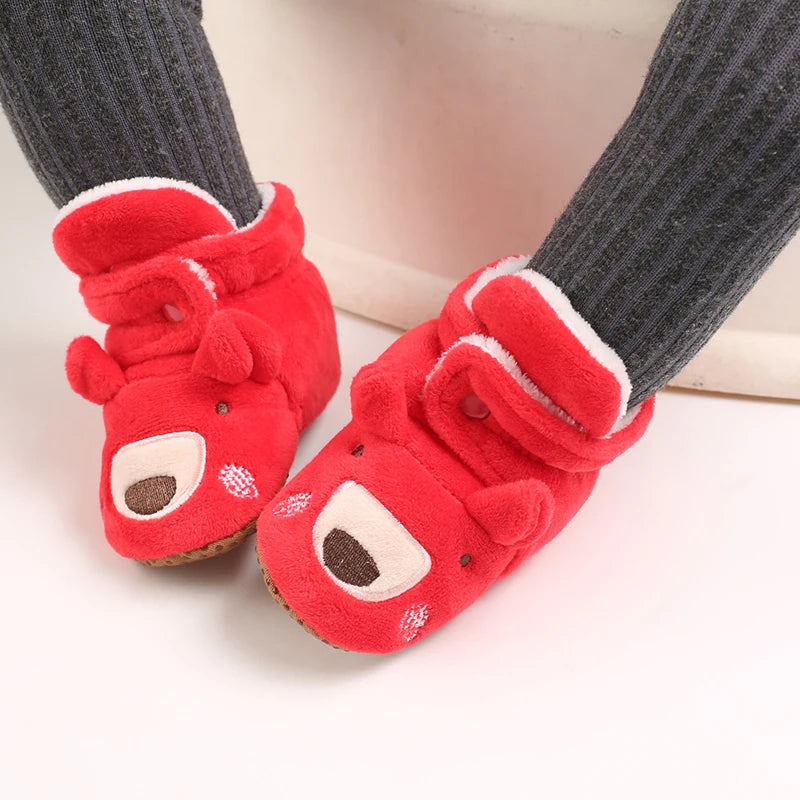 Red animal-themed slippers worn with gray socks on a light background