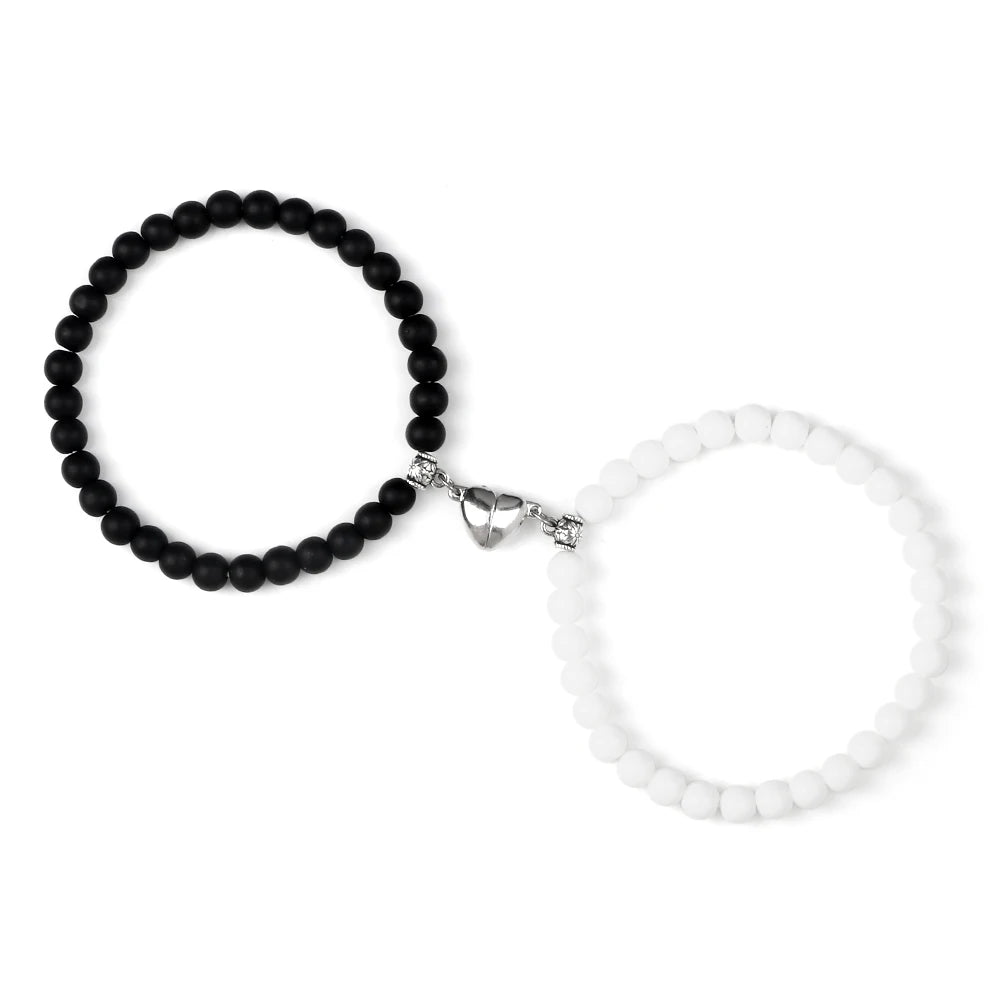 Black beaded bracelet and white beaded bracelet on a white background