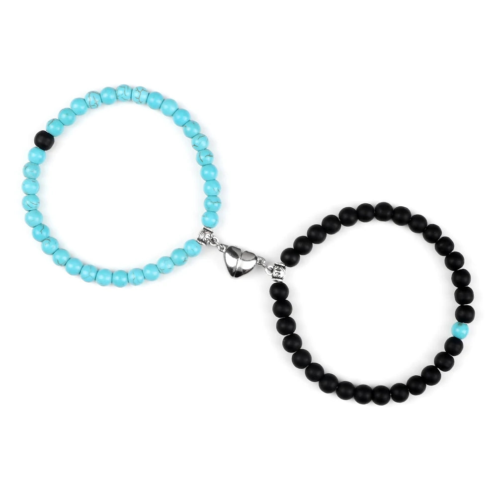 Two beaded bracelets, one light blue and one black, on a white background.