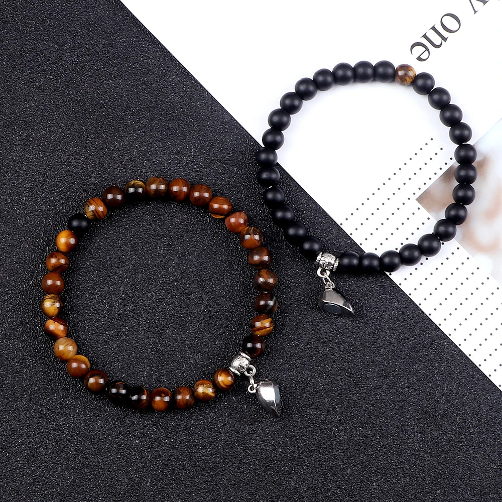 Two beaded bracelets with silver charms on a black and white background