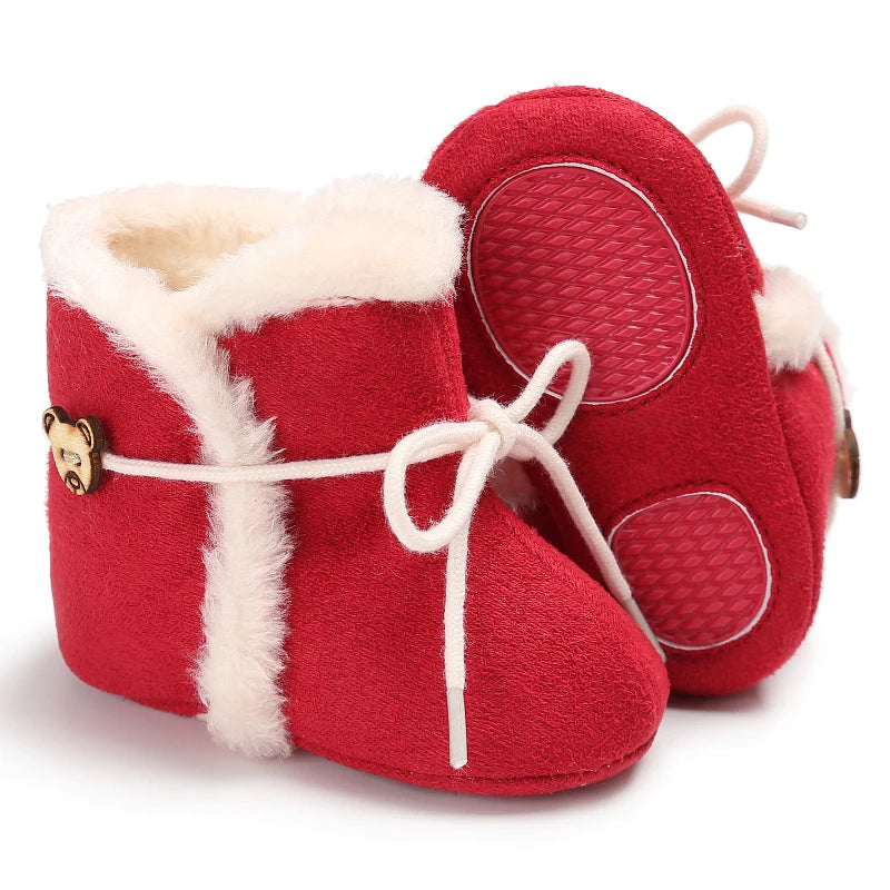 Red baby boots with white fur lining on a white background