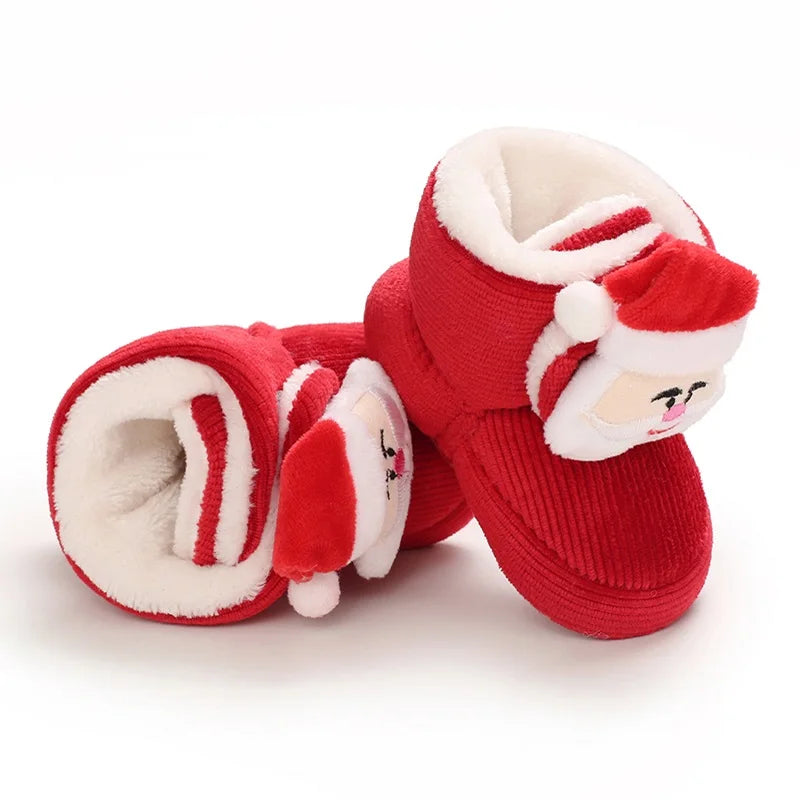 Red baby booties with white fur lining and Santa face design on a white background