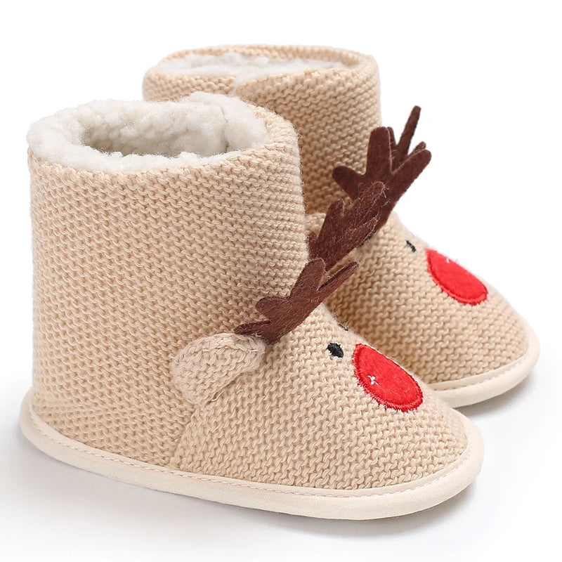 Beige knit baby boots with reindeer design on a white background