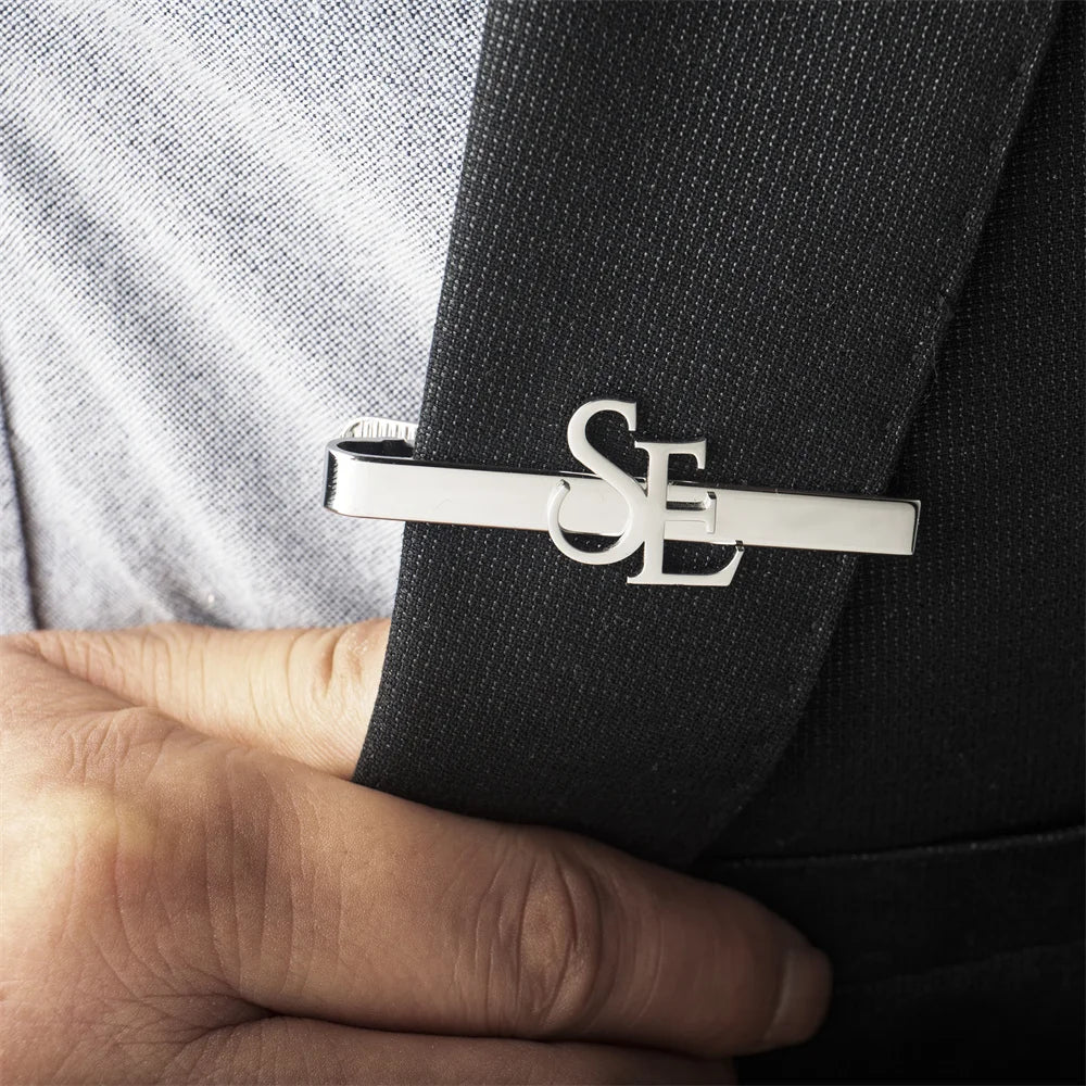 Personalised ilver tie clip with initials on a black suit lapel