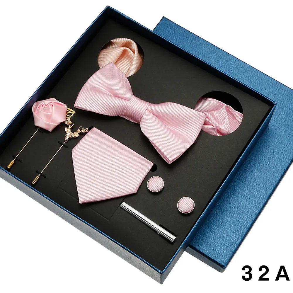 Pink bow tie and pocket square set with accessories in a box.