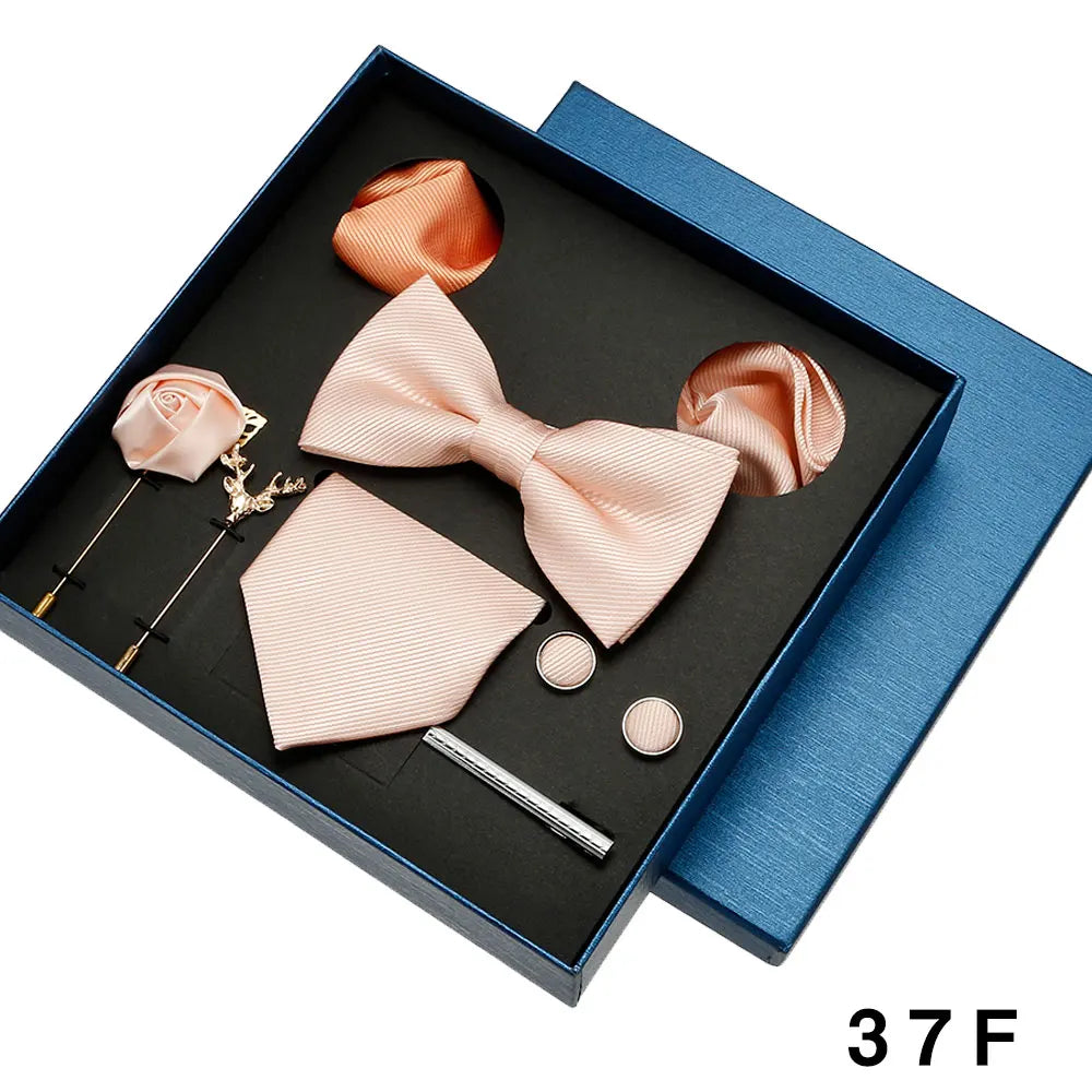 Pink bow tie and pocket square set with accessories in a blue box