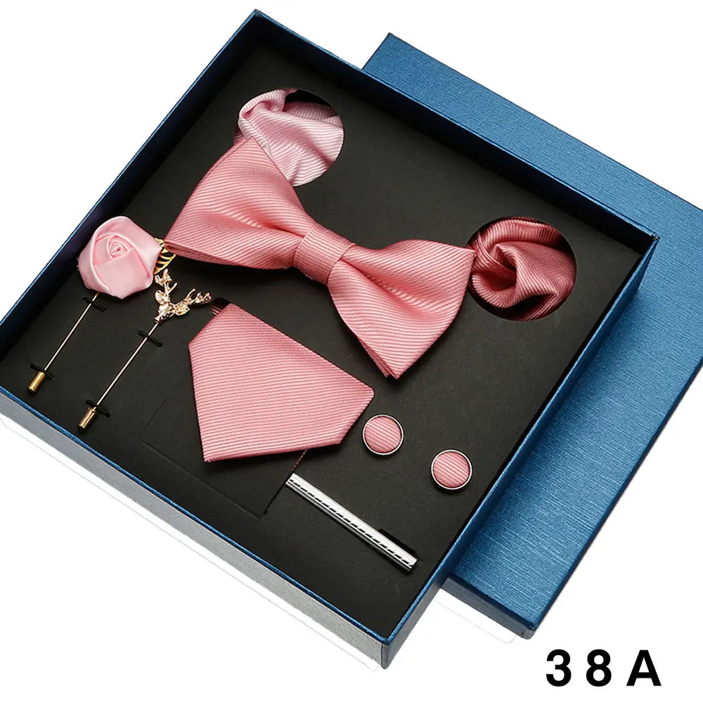 Pink bow tie and pocket square set with accessories in a blue box