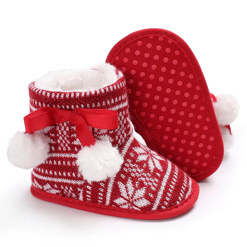 Red and white patterned baby booties with fluffy details on a white background