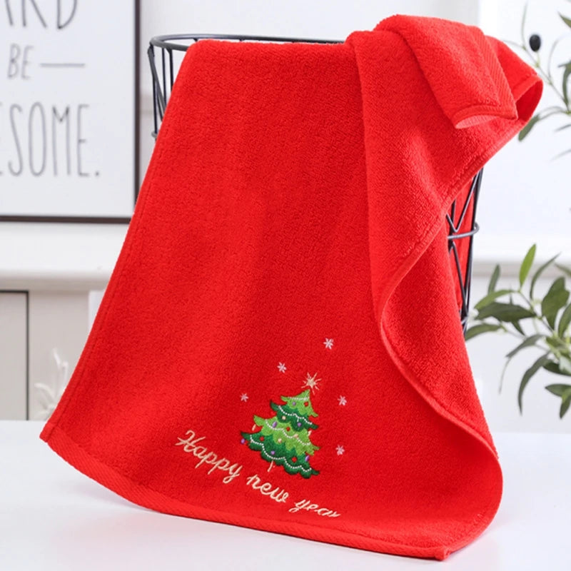 Red towel with Christmas tree and 'Happy New Year' text on a white surface.