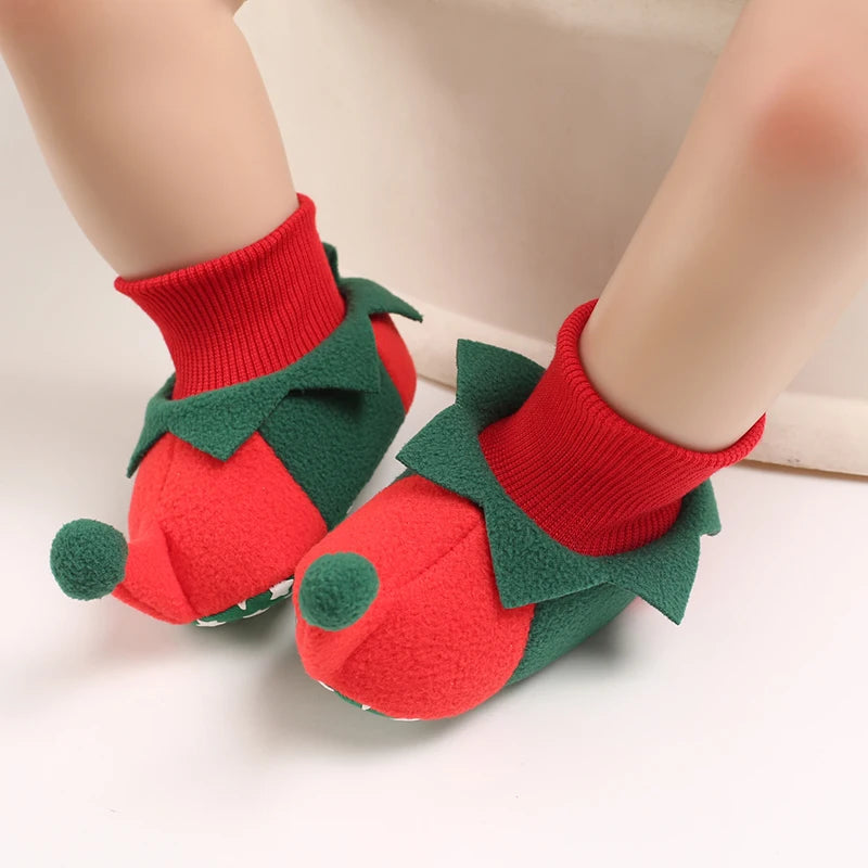 Red and green baby shoes resembling strawberries on a neutral background