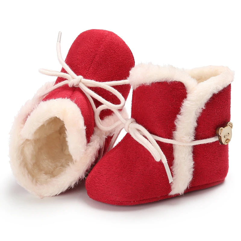 Red baby boots with white fur trim on a white background
