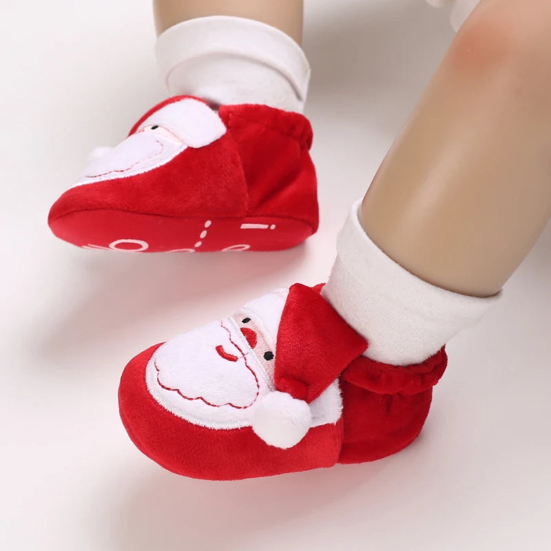 Red baby shoes with Santa Claus design on a white background