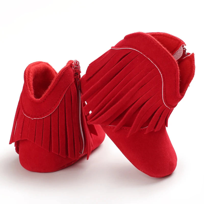 Red fringed baby boots on a white background