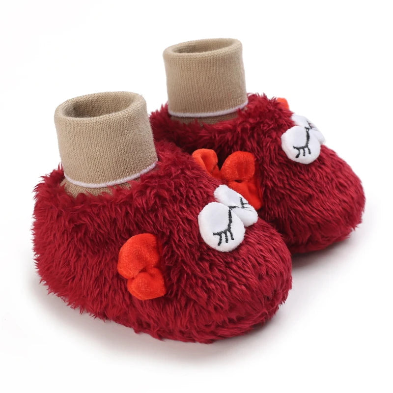 Red fuzzy baby shoes with beige cuffs on a white background