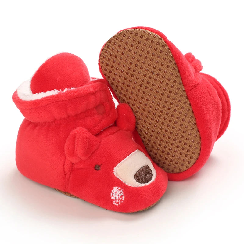 Red baby booties with a textured sole on a white background