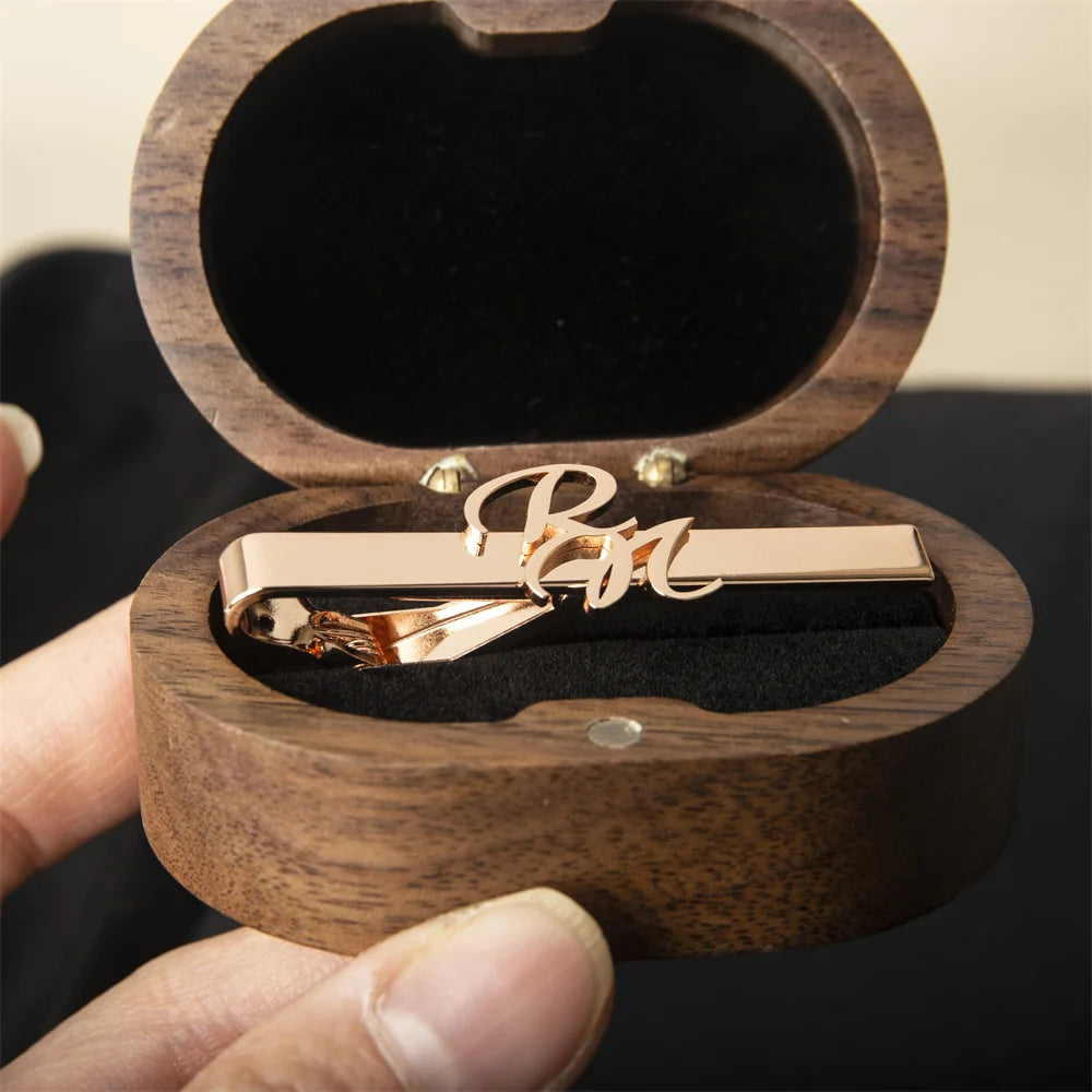 Rose gold customized tie clip in a wooden box held by a hand