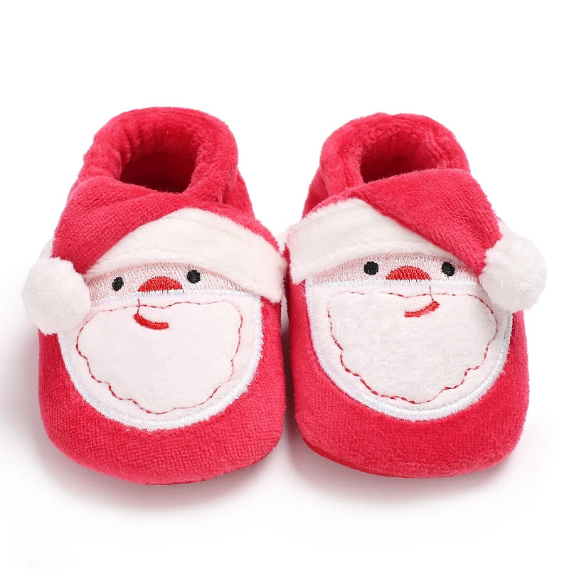 Red baby shoes with Santa face design on a white background