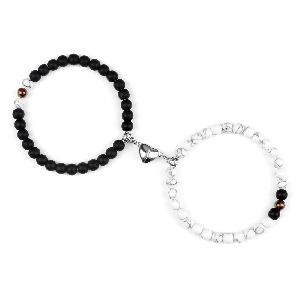 Black beaded bracelet and silver chain bracelet on a white background