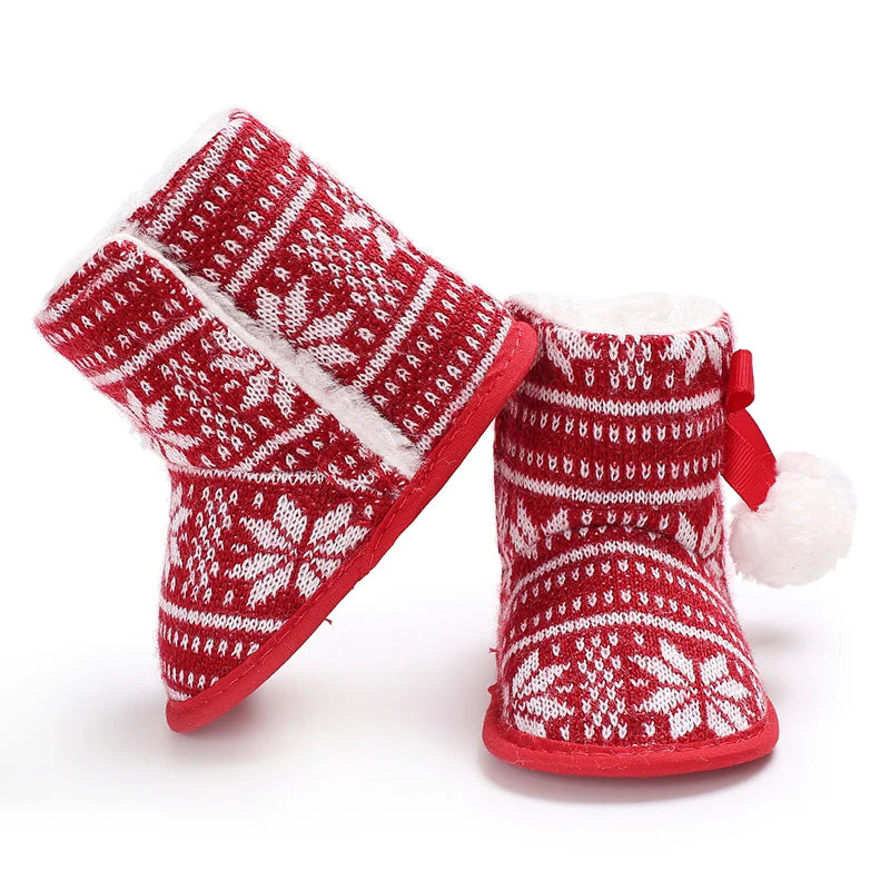 Red and white patterned baby booties on a white background