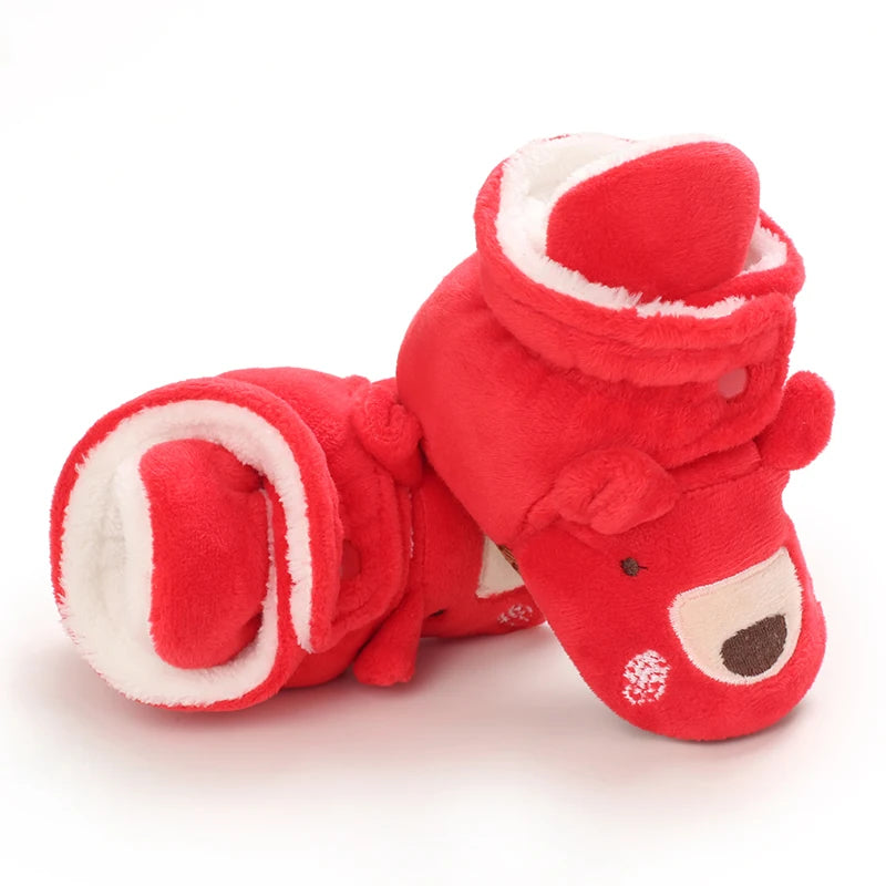 Red plush slippers with a face design on a white background