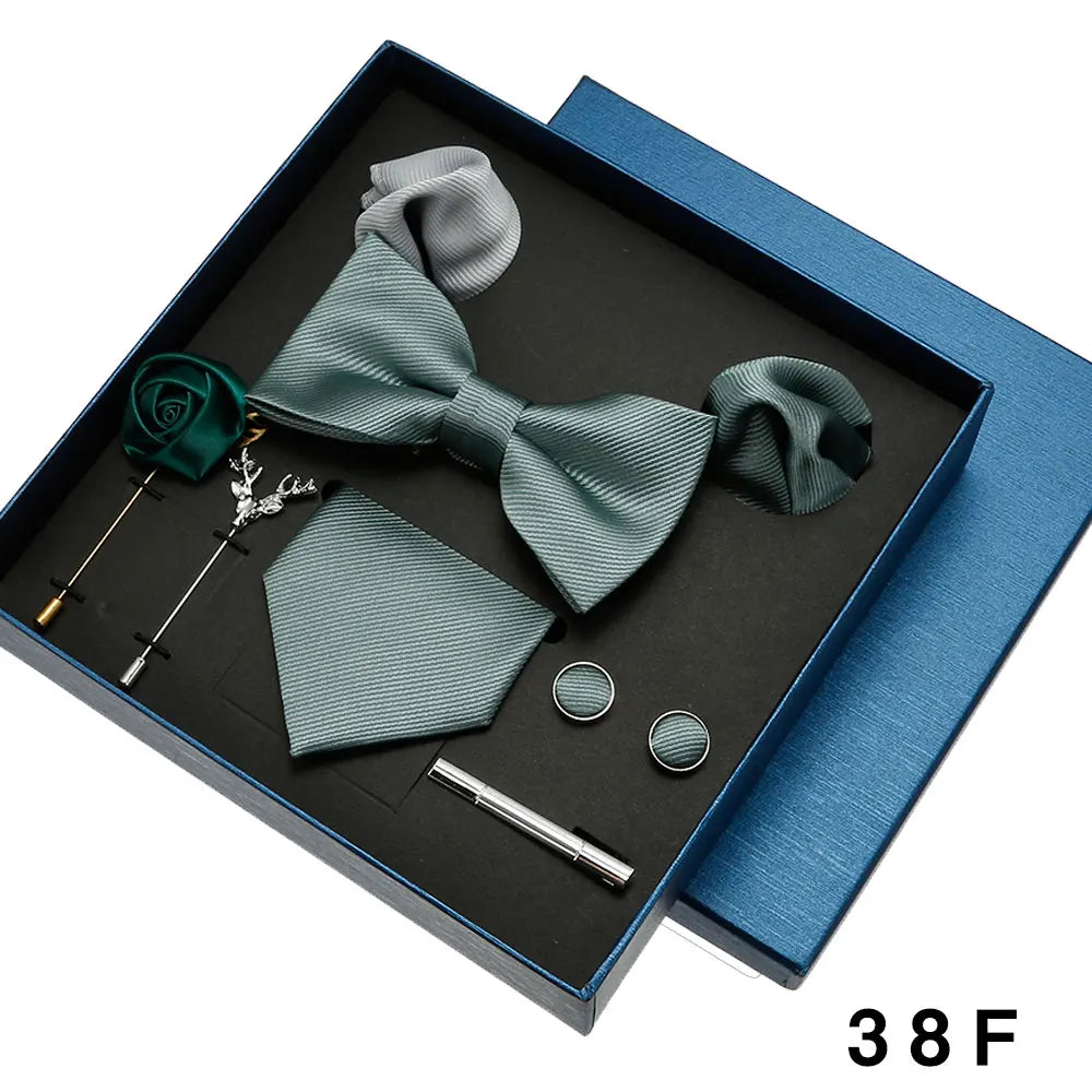 Teal bow tie and pocket square set with accessories in a blue box.