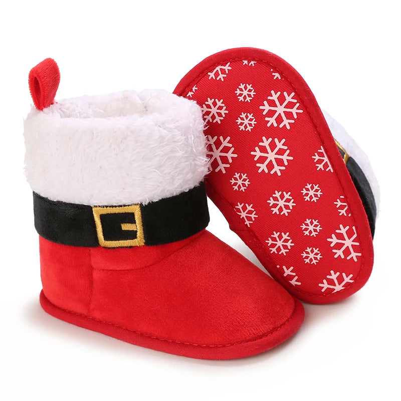 Red baby booties with white snowflake pattern on a white background
