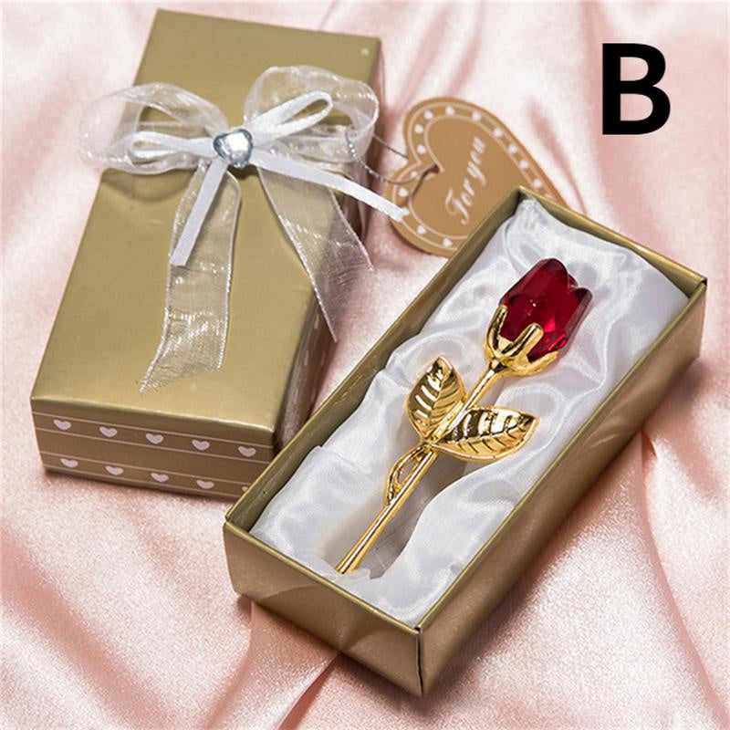 Gold rose with red stone in a decorative box on a pink background