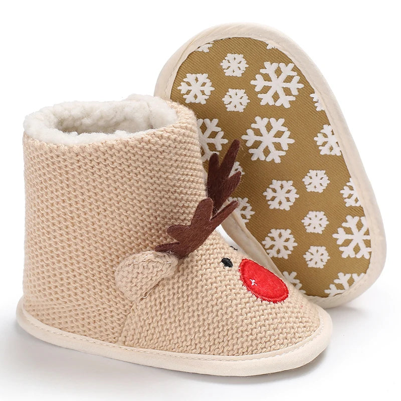 Beige knit baby booties with reindeer design and snowflake pattern on sole.
