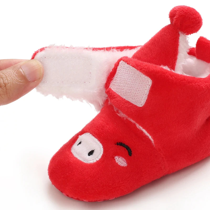 Red baby bootie with a face design on a white background
